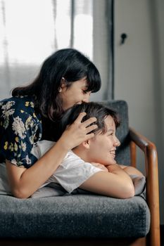 两个女人在室内的沙发上分享快乐的时刻，表达幸福