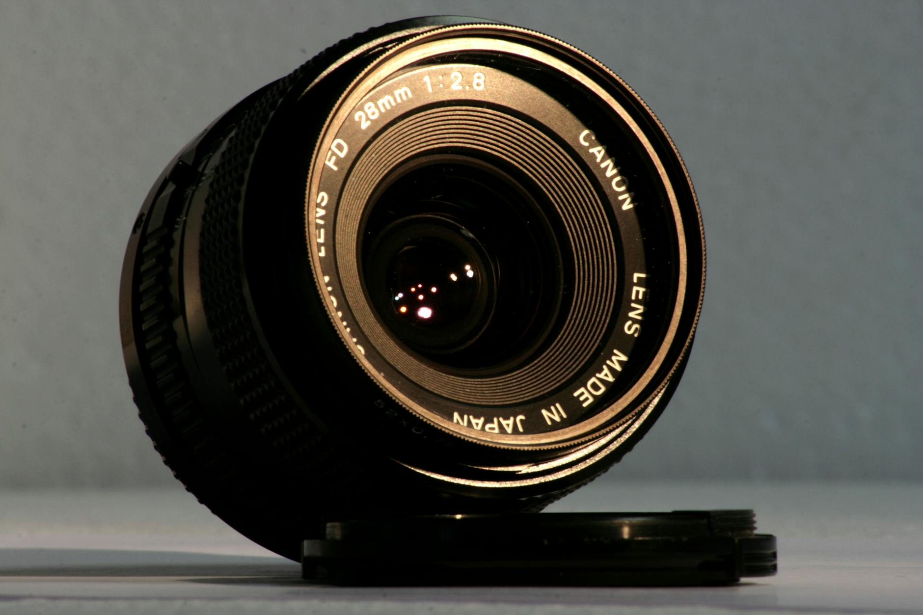 Detailed close-up of a Canon lens with its lens cover, ideal for photography equipment themes.
