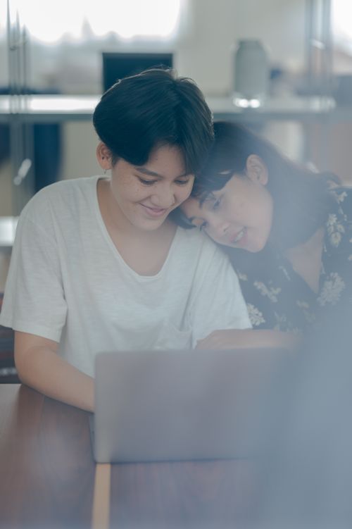 Free A smiling couple collaborating on a laptop, showcasing warmth and togetherness indoors. Stock Photo
