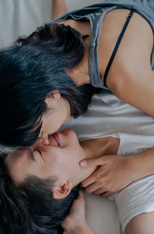 Free An intimate moment between a loving couple sharing smiles and affection indoors. Stock Photo