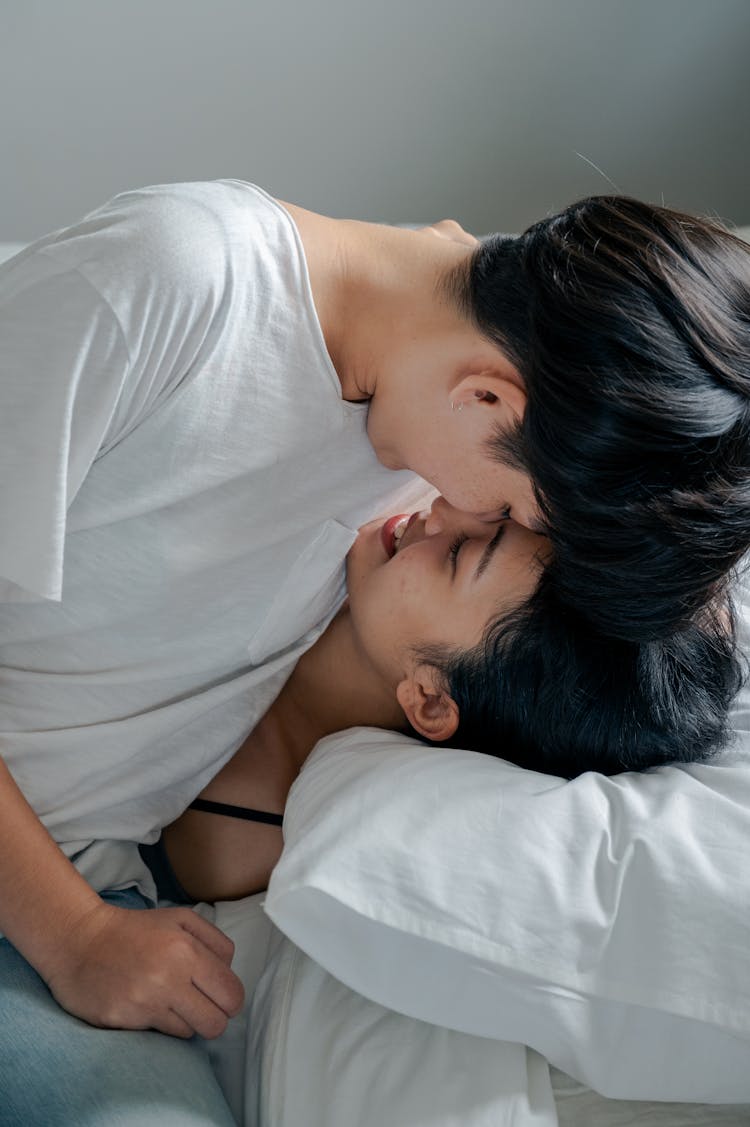 Women Touching Foreheads While Lying In Bed