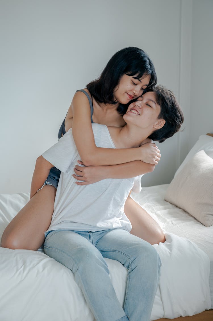 Lesbian Couple Embracing In Bed