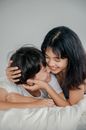 两个女人在床上拥抱的温柔时刻，捕捉到了真正的快乐与亲密