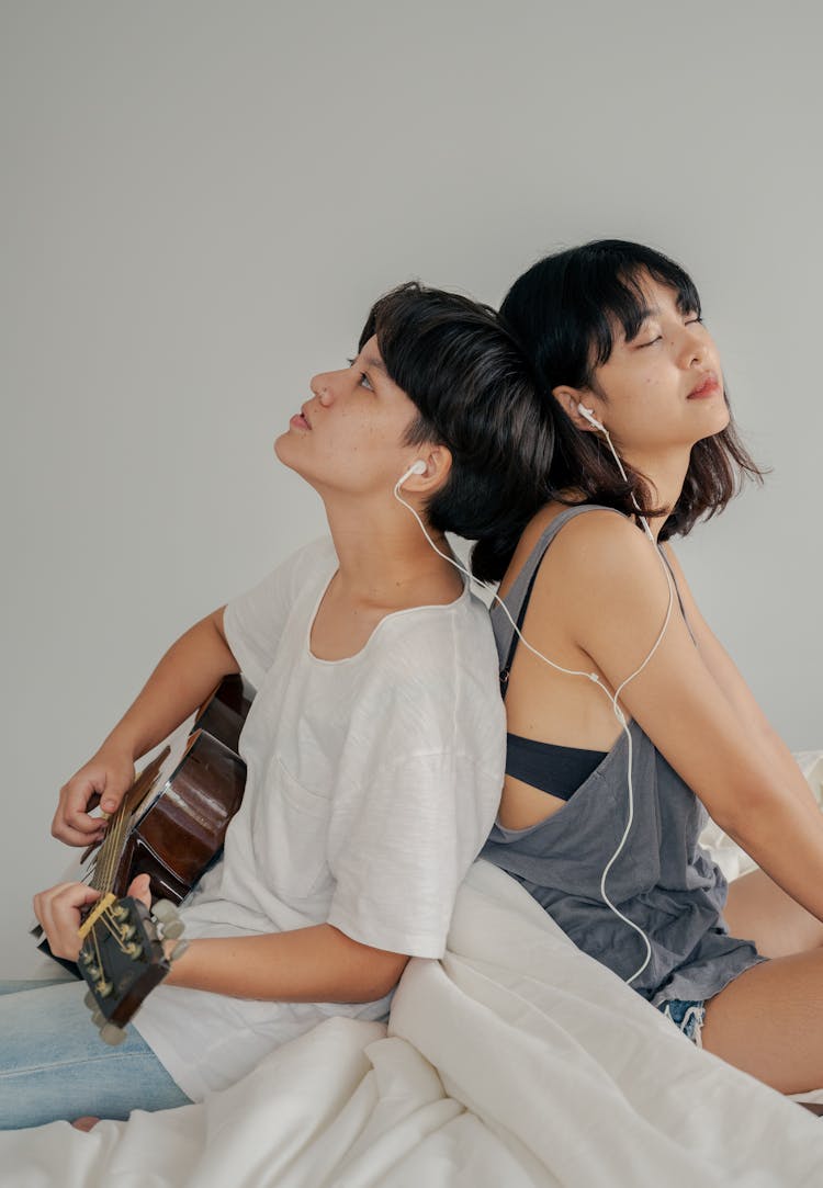 Photo Of Couple Sitting Next To Each Other While Listening To Music