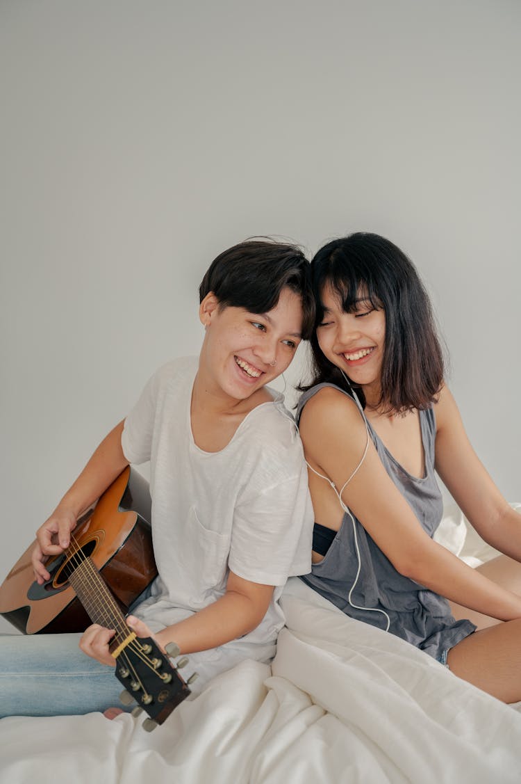 Photo Of Couple Sitting Next To Each Other While Listening To Music