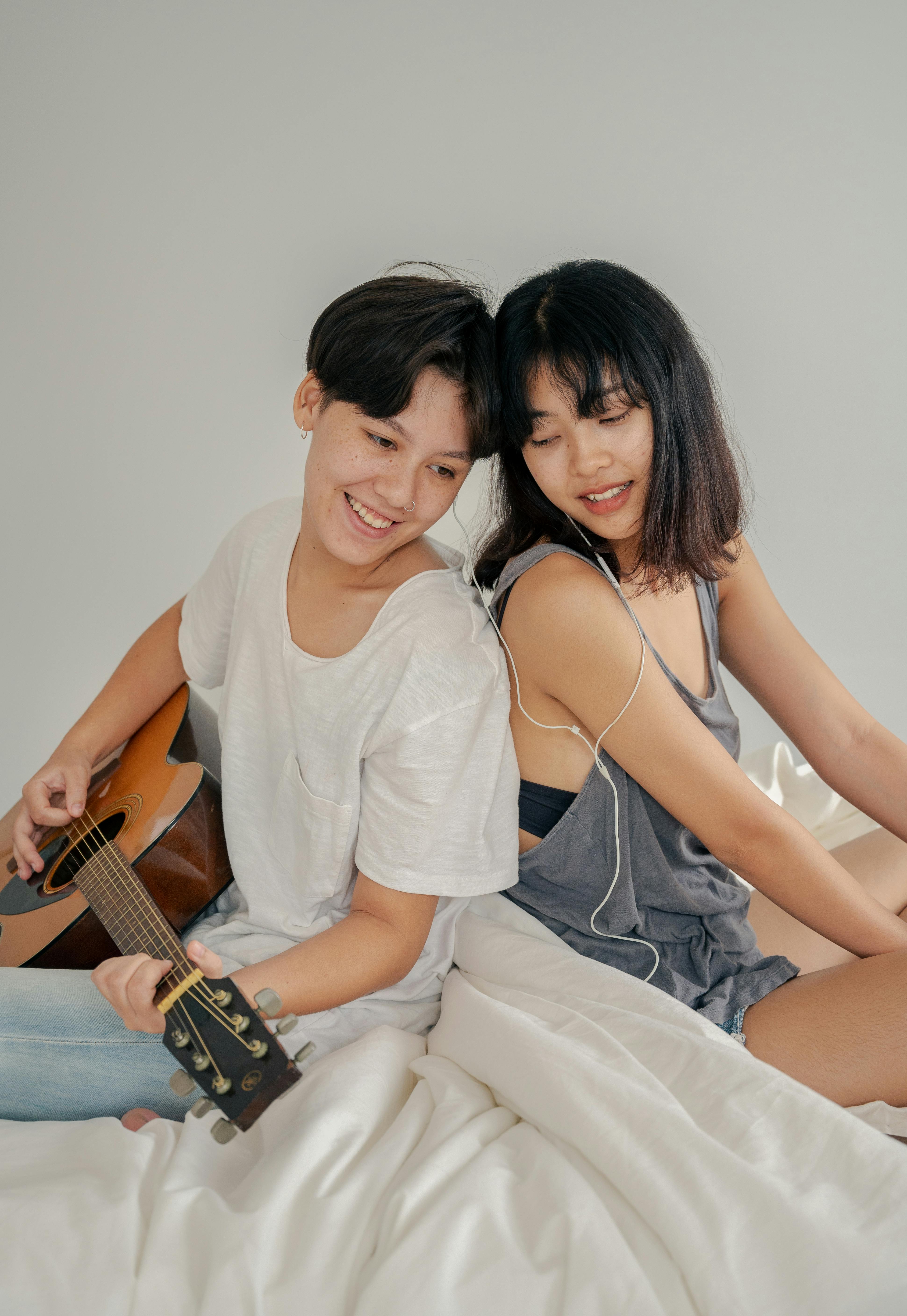 photo of couple sitting next to each other while listening to music