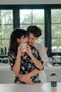 一对恩爱夫妻在室内喝咖啡时，分享了一个温暖的拥抱