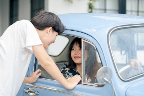 Photo of Woman Inside the Car While Looking at Her Boyfriend