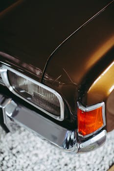 Close-up of a vintage brown car with chrome and classic details, emphasizing nostalgia.