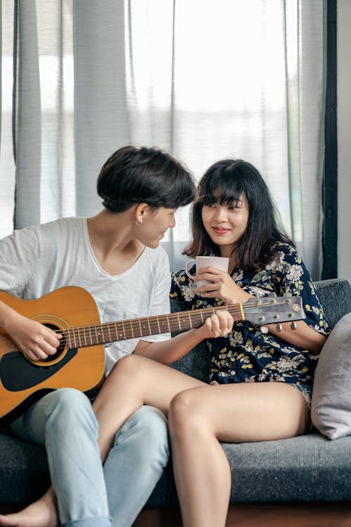 Free Photo of Man Playing Acoustic Guitar With Her Woman Stock Photo