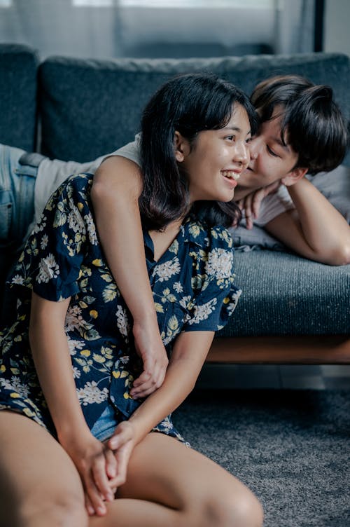 Free Photo of Couple Sitting on Couch and Floor Stock Photo