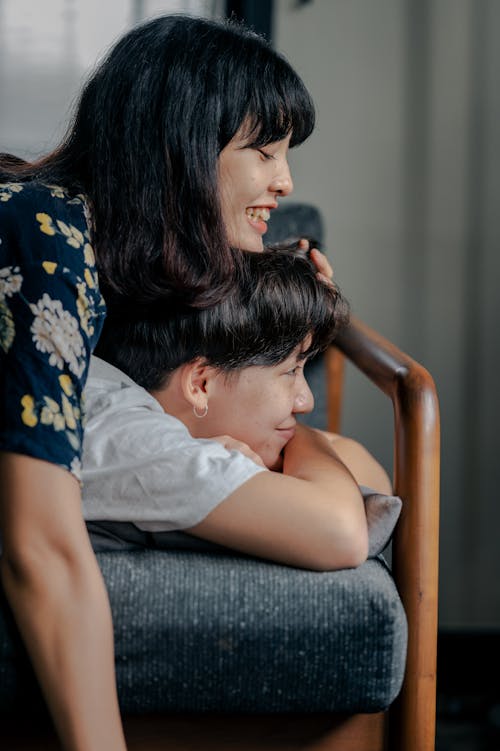 Photo of Couple Having Fun While Lying on Couch