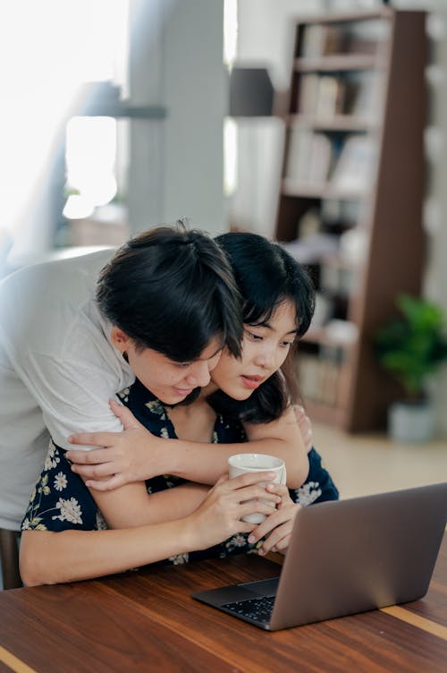 Photo of Couple Looking at Laptop