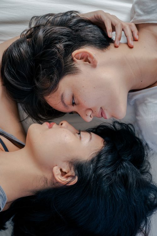 Free Two women lying face to face, sharing an intimate, peaceful moment. Stock Photo
