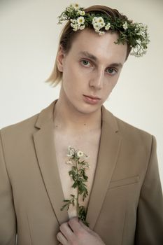 Stylish portrait of a young adult wearing a beige coat and floral crown indoors. - Fotografer Sidoarjo
