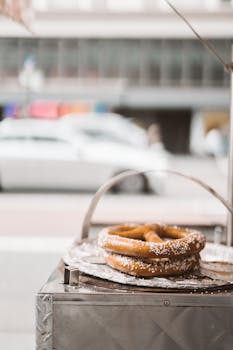 Enjoy freshly baked pretzels with salt on a city street food cart, perfect for a quick snack.