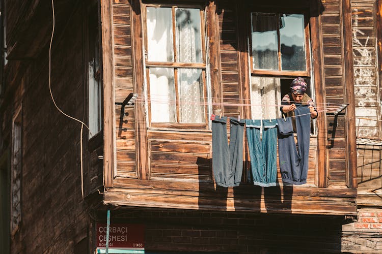 A Woman Hanging Pants On The Clothesline