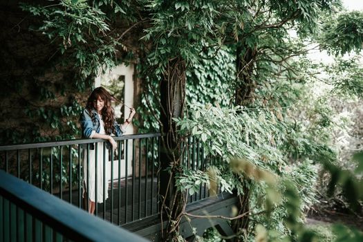 一个女人在绿叶环绕的阳台上享受宁静时光