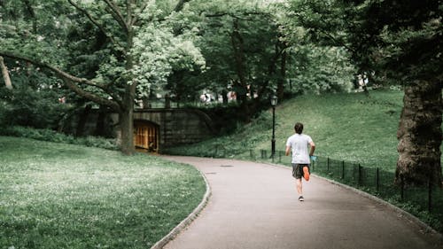 Photo of Man Jogging on Paved Pathway