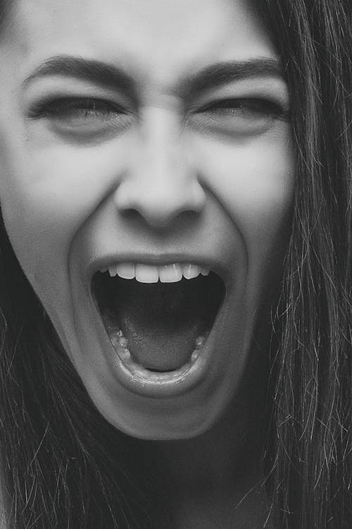 Grayscale Photo of Person Screaming