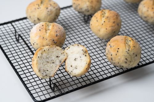 Free Homemade sesame buns cooling on a wire rack, perfect for serving with soup or salad. Stock Photo