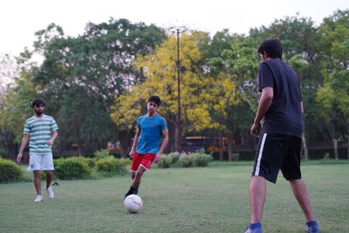 Free Young men playing soccer outdoors on a sunny day, enjoying an active lifestyle. Stock Photo