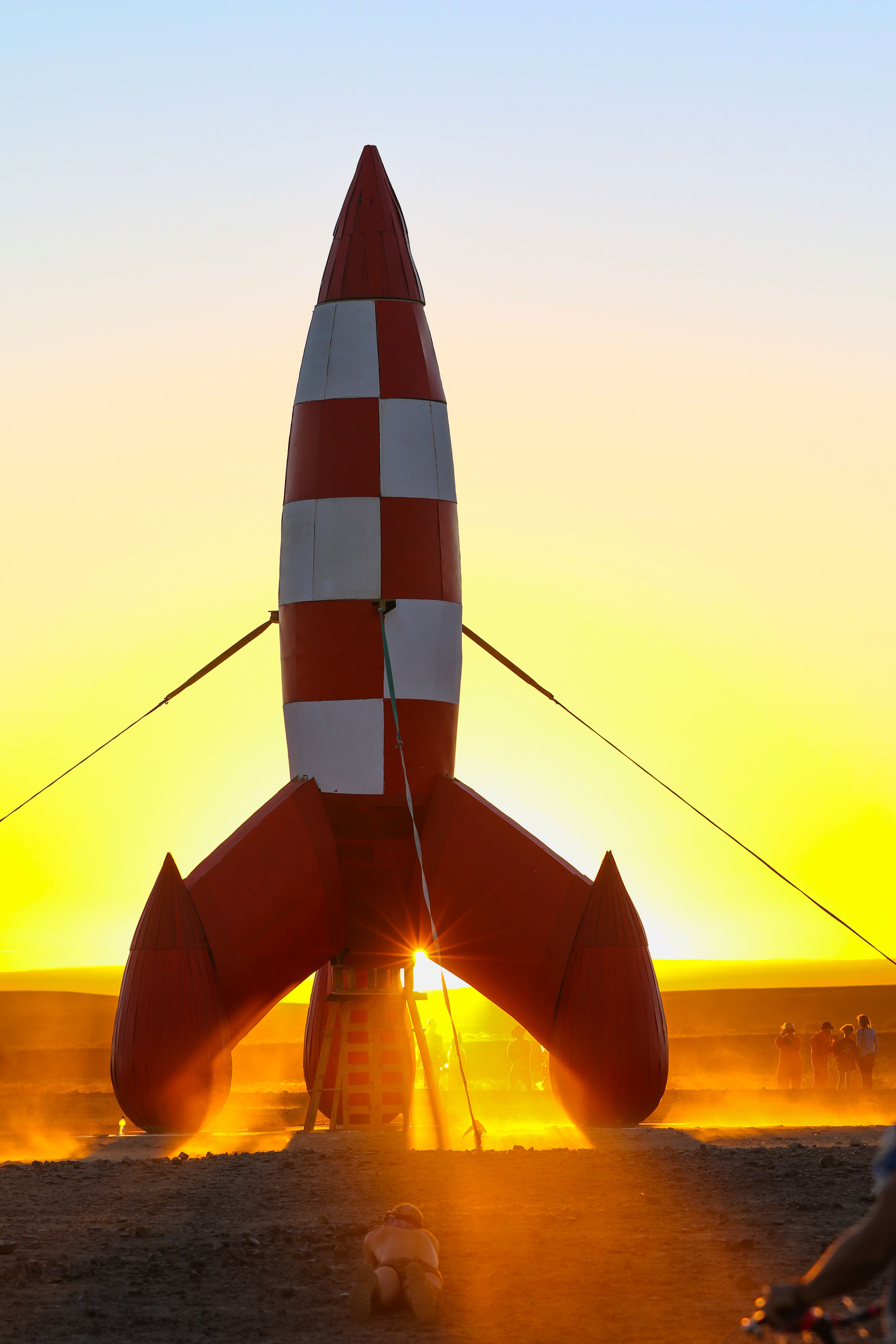 A vibrant rocket installation at sunset during AfrikaBurn festival in South Africa.
