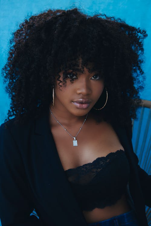 Kostenloses Stock Foto zu afro-haar, blauem hintergrund, emotionslos