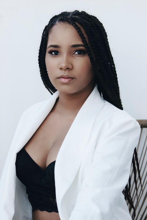Free A confident woman in a white blazer and black top, showcasing sophisticated style. Stock Photo