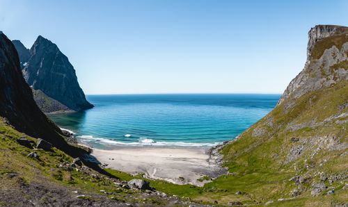 Free A breathtaking view of Lofoten's pristine beach and turquoise waters surrounded by majestic cliffs. Stock Photo