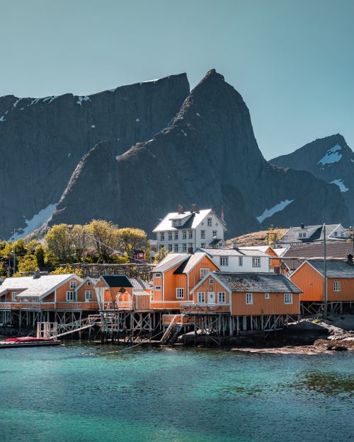 Free Charming fishing village with colorful houses, set against majestic mountains in Nordland, Norway. Stock Photo