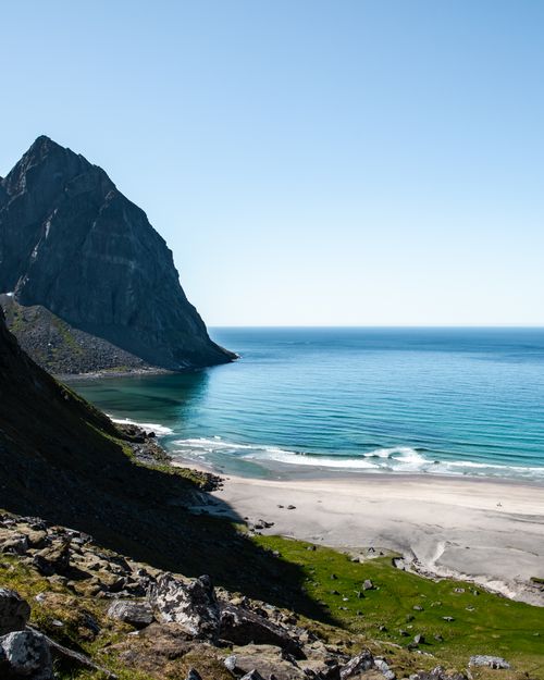 Free Breathtaking view of a serene beach next to a towering mountain in Moskenes, Norway. Stock Photo