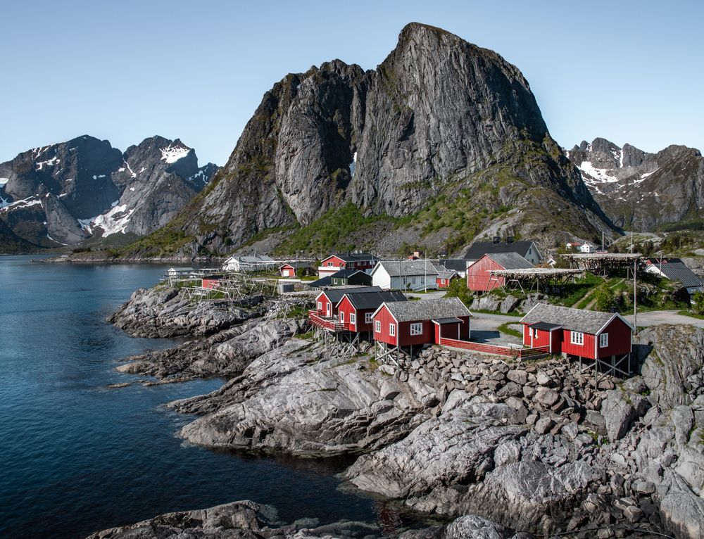 Cabane roșii de pescari la Hamnøy, în Lofoten, cu munți în fundal