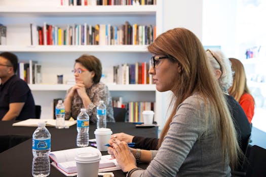 Business professionals meeting in modern office with bookshelves. Collaborative and focused environment.