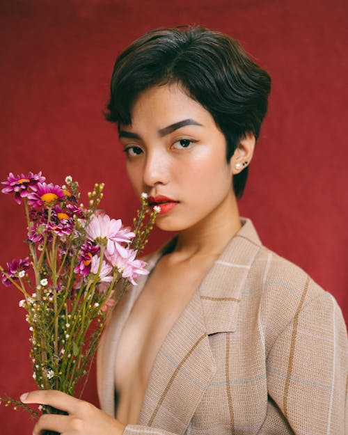 Mujer En Chaqueta Beige Con Flores Rojas Y Amarillas