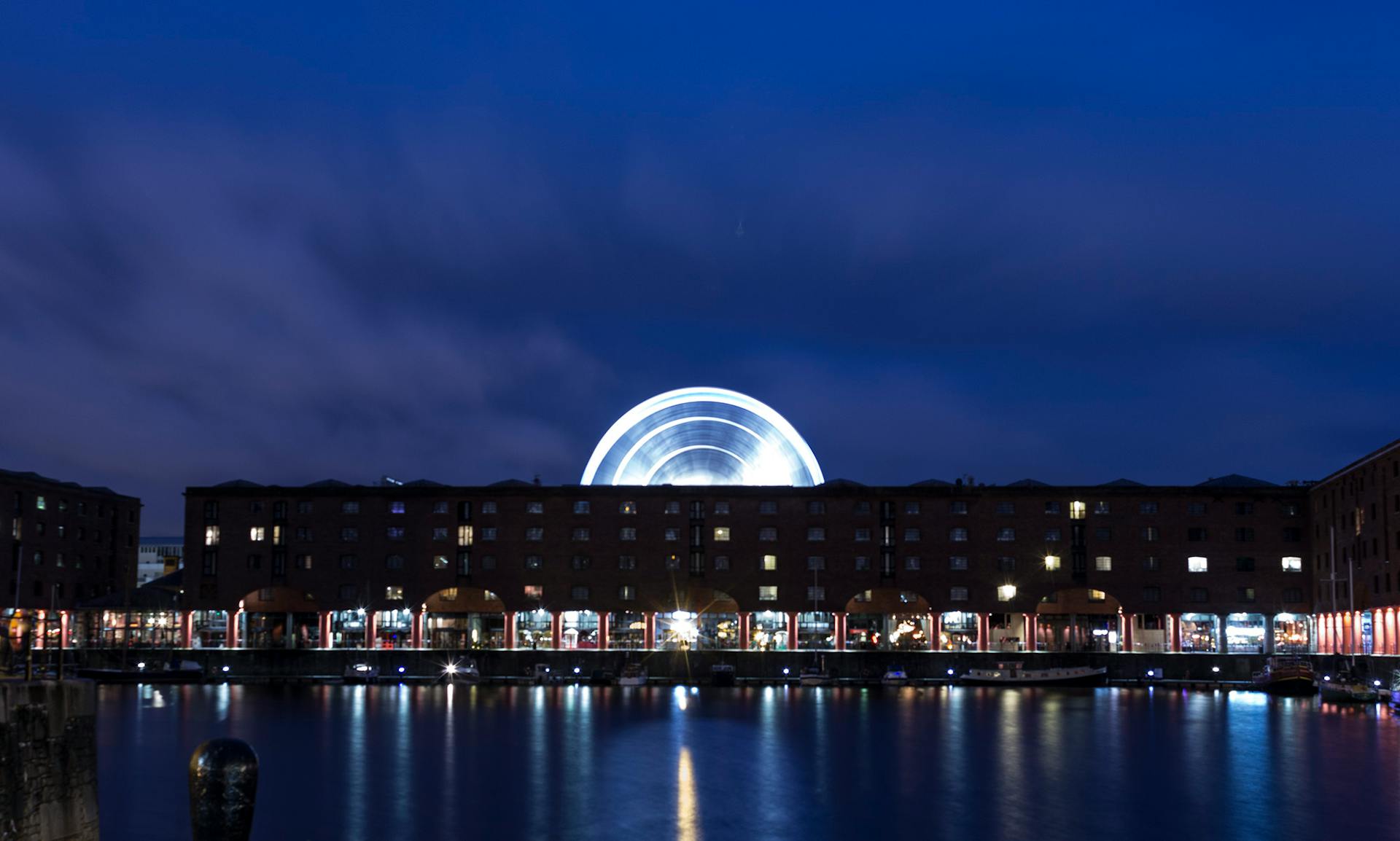 A captivating night cityscape featuring Albert Dock in Liverpool with an illuminated Ferris wheel.