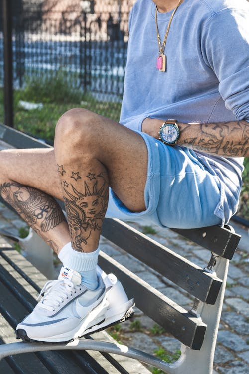 Man Wearing Nike Sneakers Sitting on Park Bench