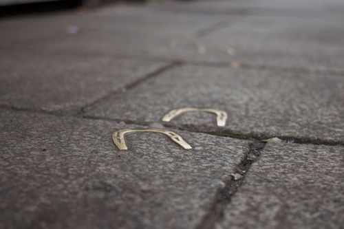 Free Close-up of horseshoes embedded in a city sidewalk, symbolizing luck and fortune. Stock Photo
