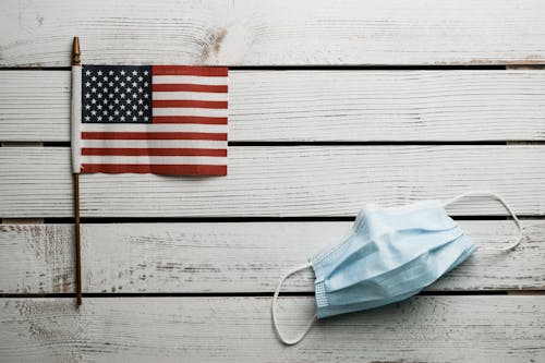 American Flag and disposable mask on wooden table