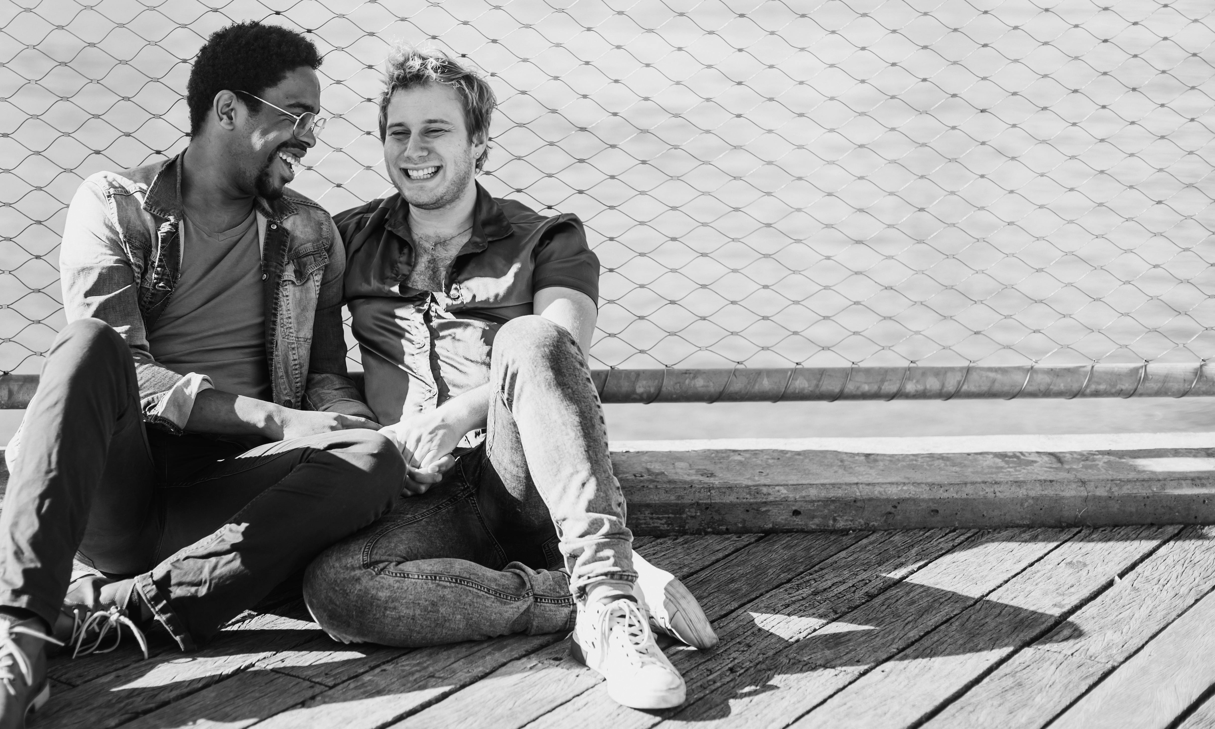 阳光下的码头上，两个人手牵着手，微笑着