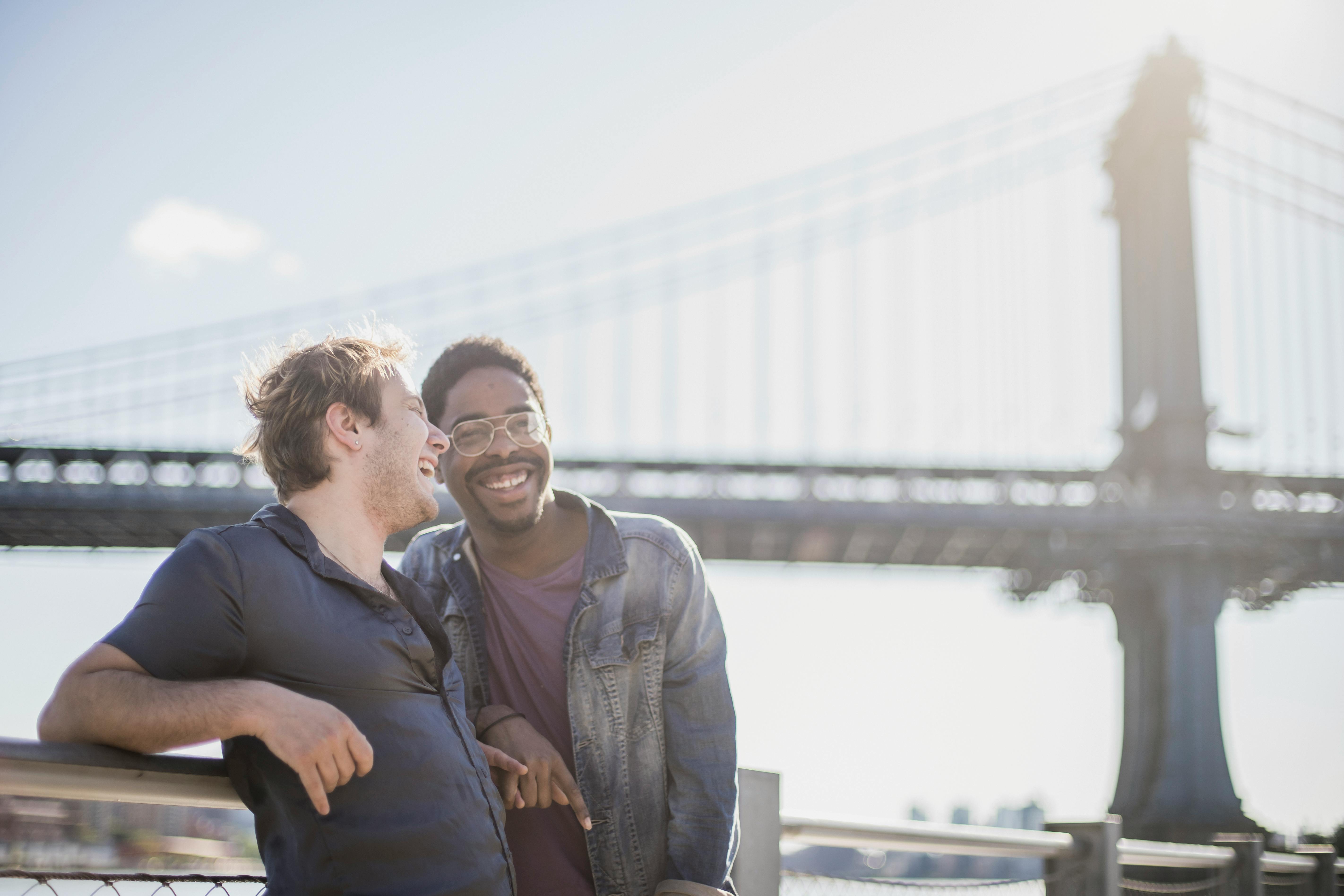 两个朋友在城里的桥边，享受着阳光明媚的一天，分享着笑声与微笑