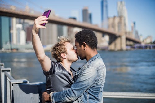 Free Couple Kissing and Taking a Selfie Stock Photo