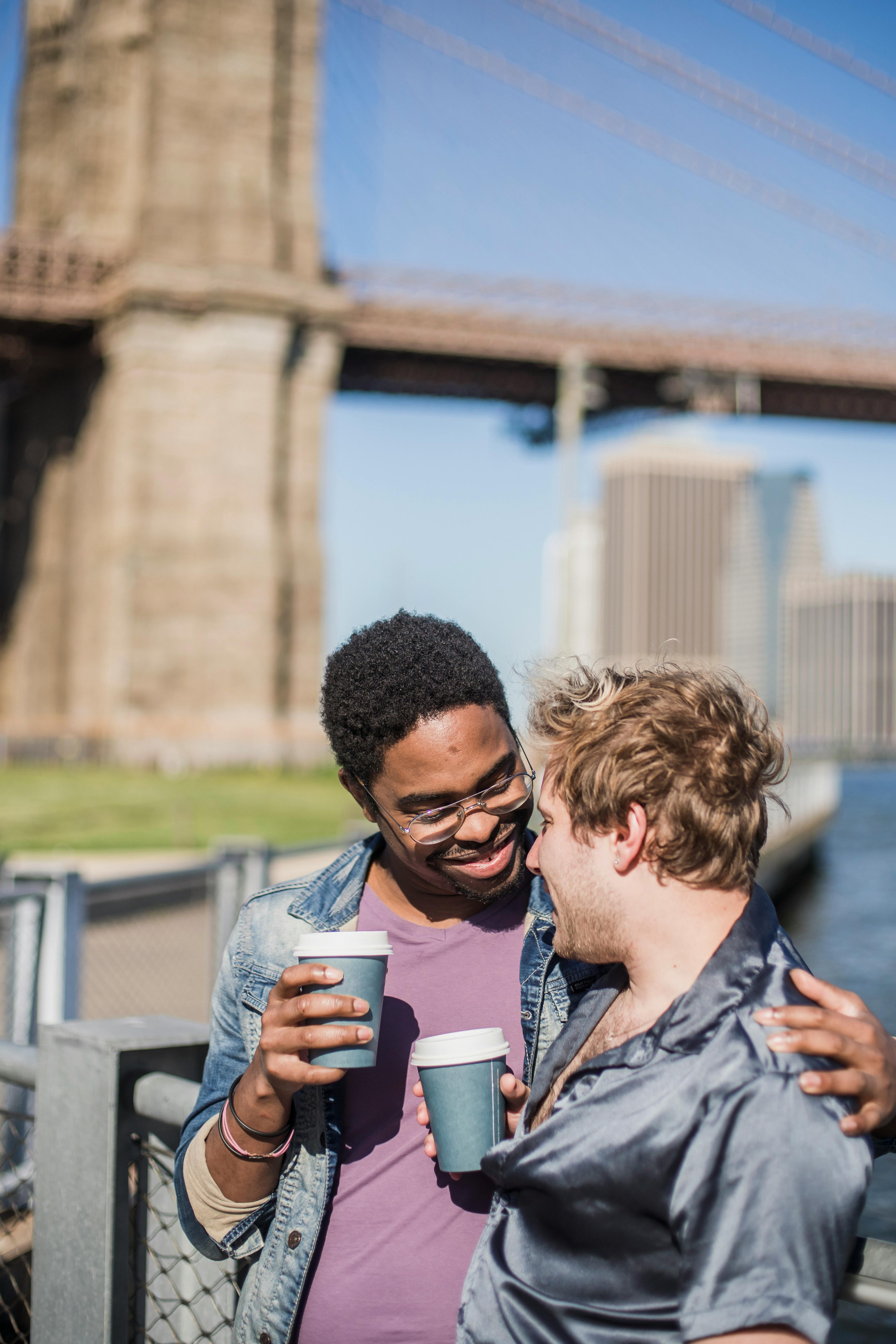 two men holding paper cups looking at each other