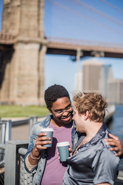Free Two Men Holding Paper Cups Looking at Each Other Stock Photo