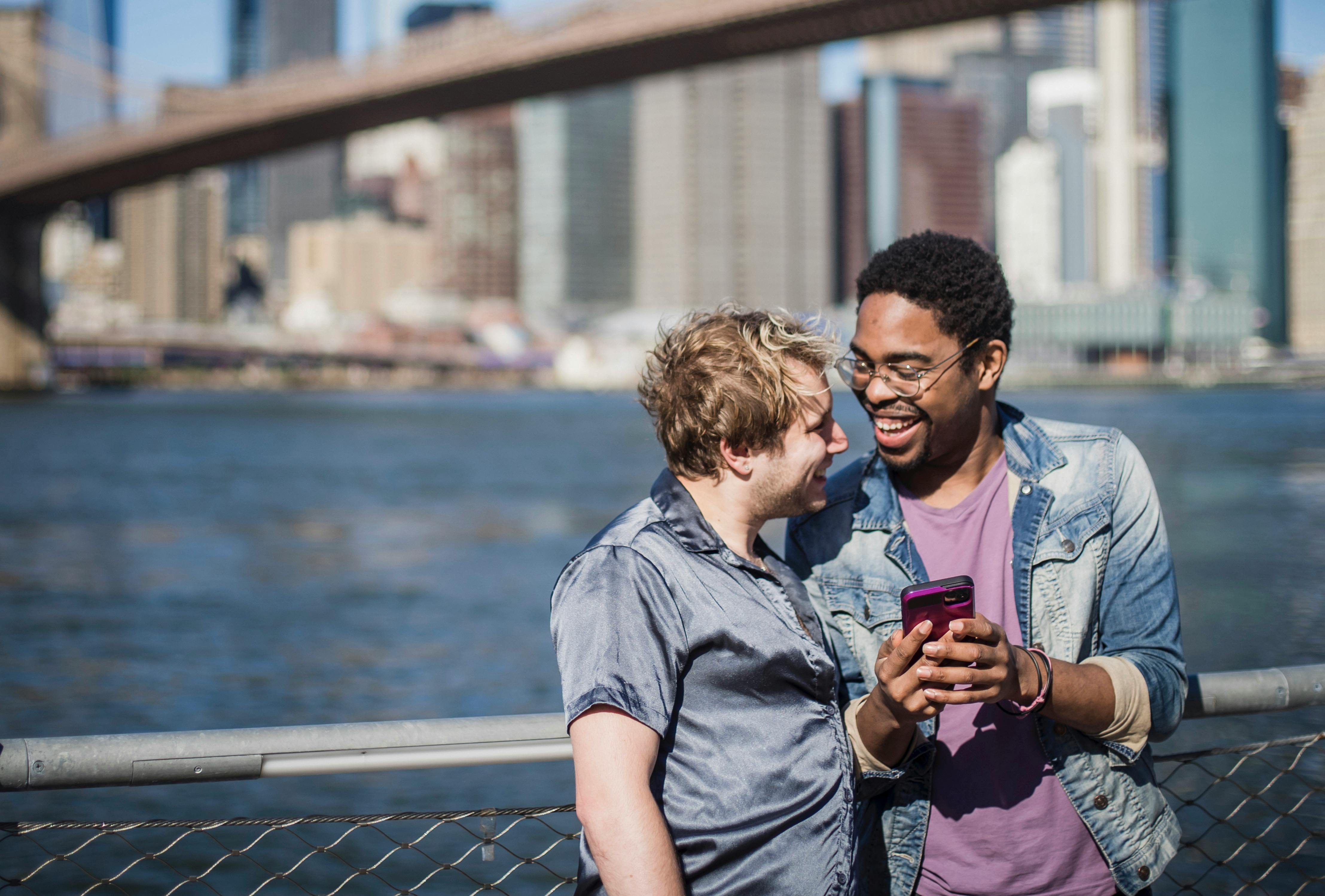 man holding a smartphone and looking at another man