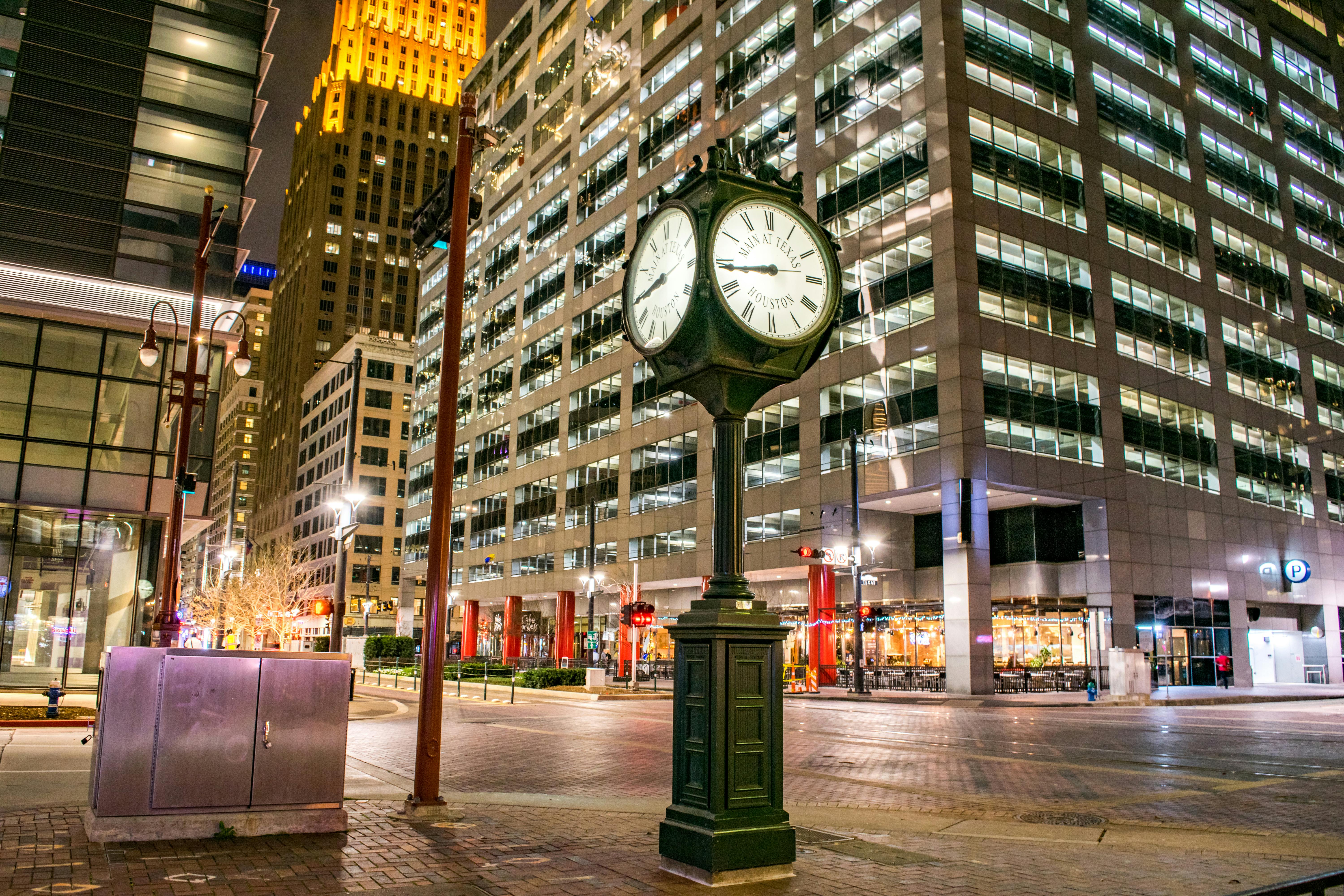 green street light near brown concrete building during nighttime