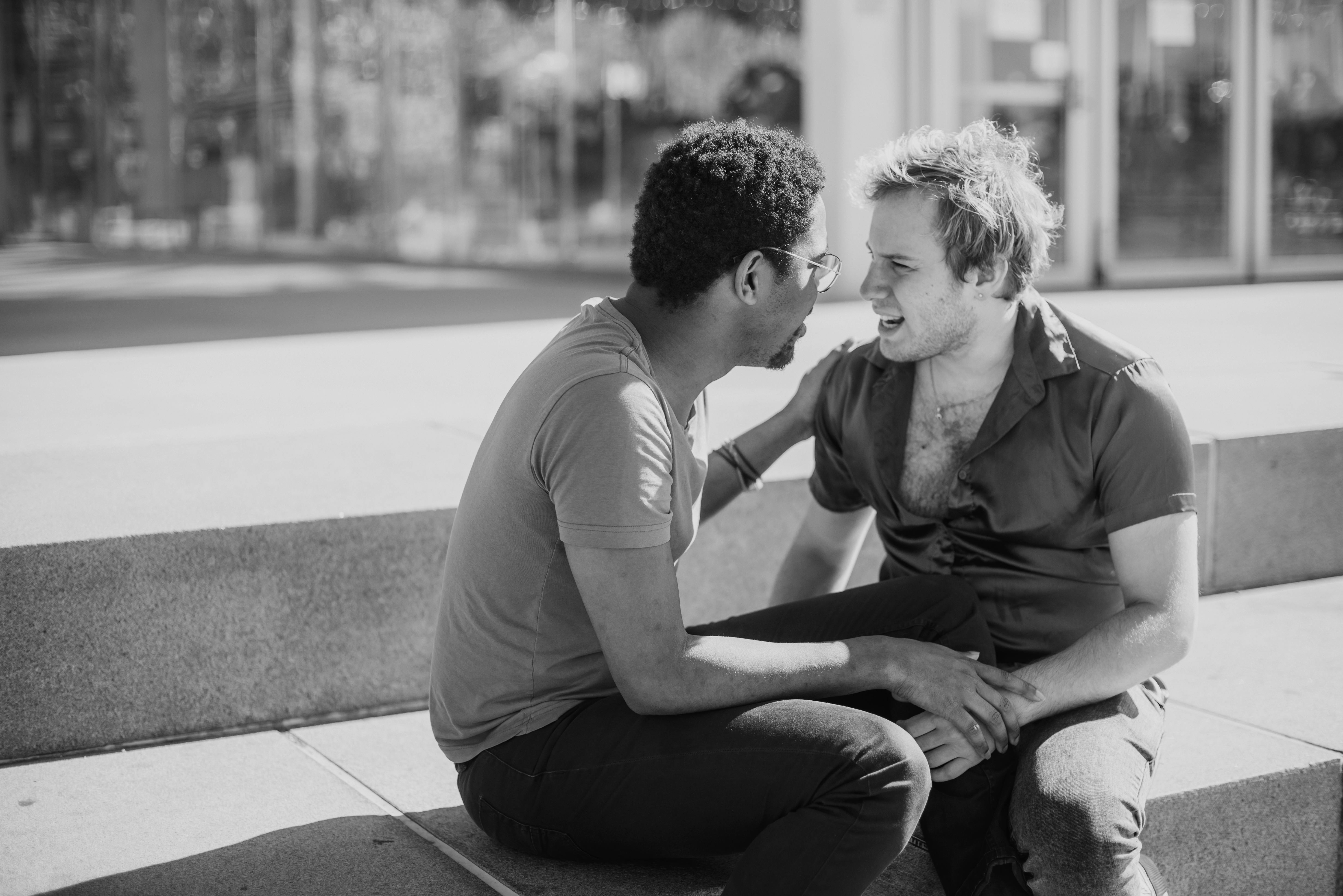 grayscale photo of two men talking