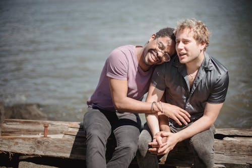 Men Holding Hands and Sitting Together