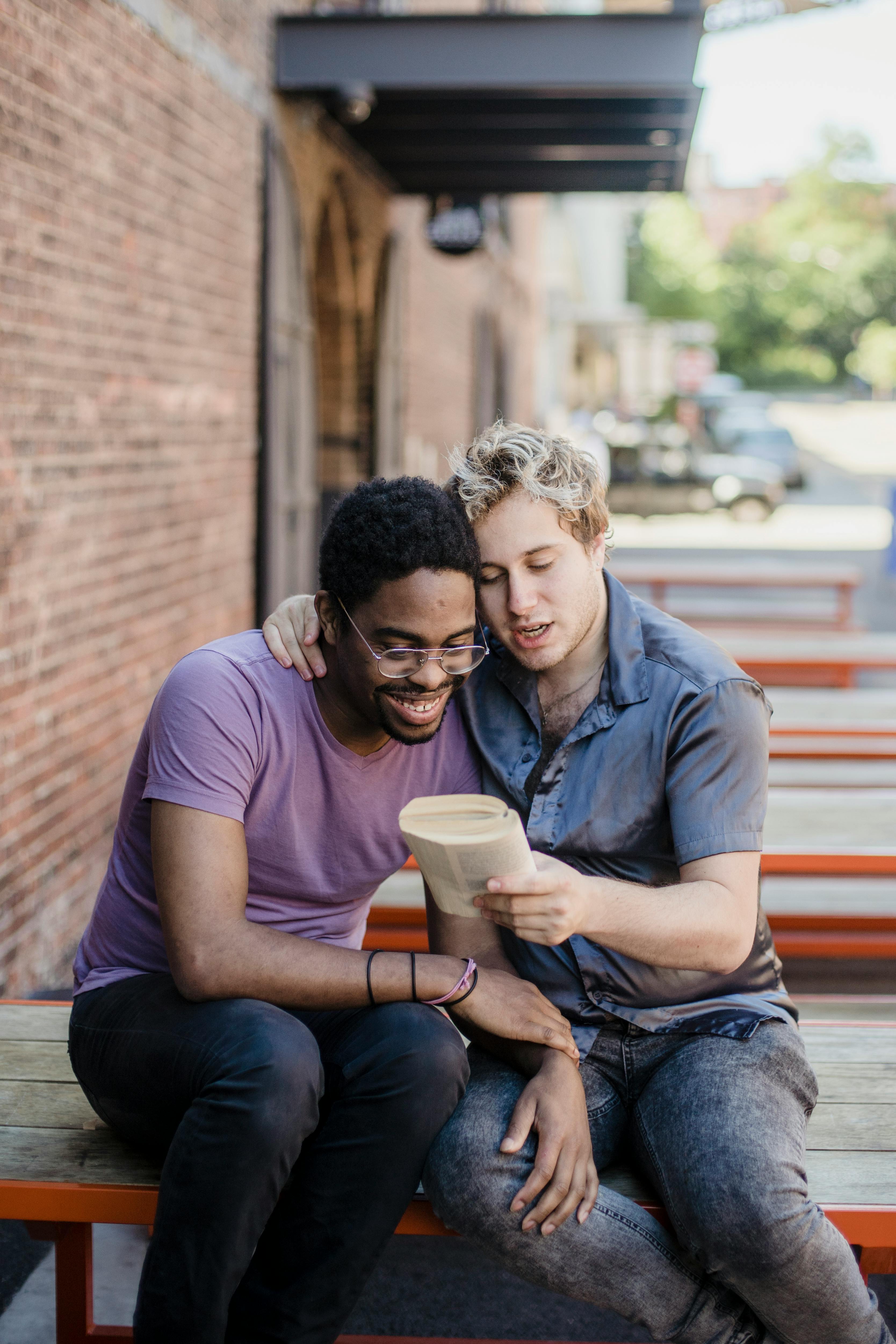 men sitting and reading a book together