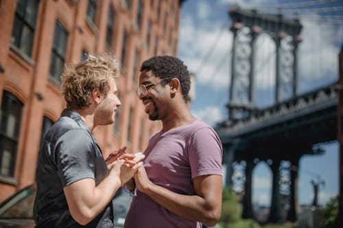 Free Men Holding Hands and Looking at Each Other Stock Photo